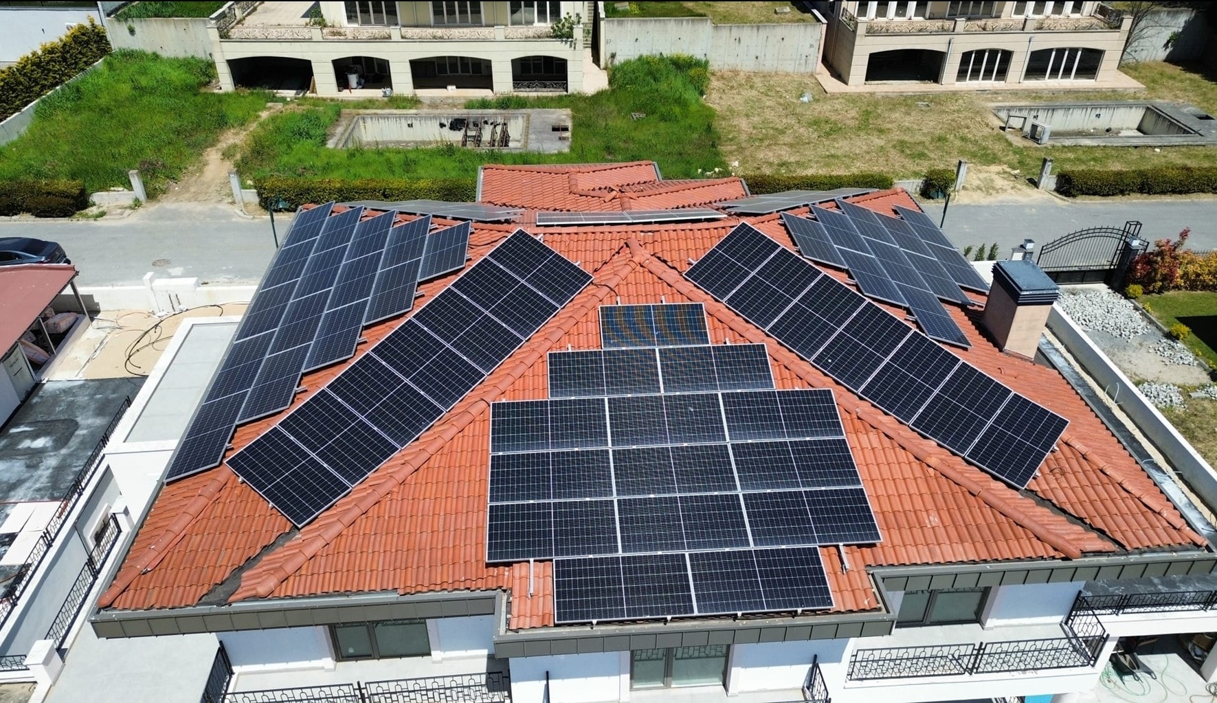 Vue aérienne d'un champ de panneaux solaires posé sur une toiture en tuiles